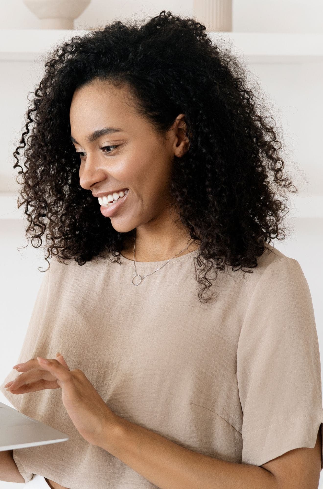 A smiling woman working on a laptop