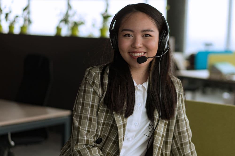 A smiling customer support agent wearing a headset