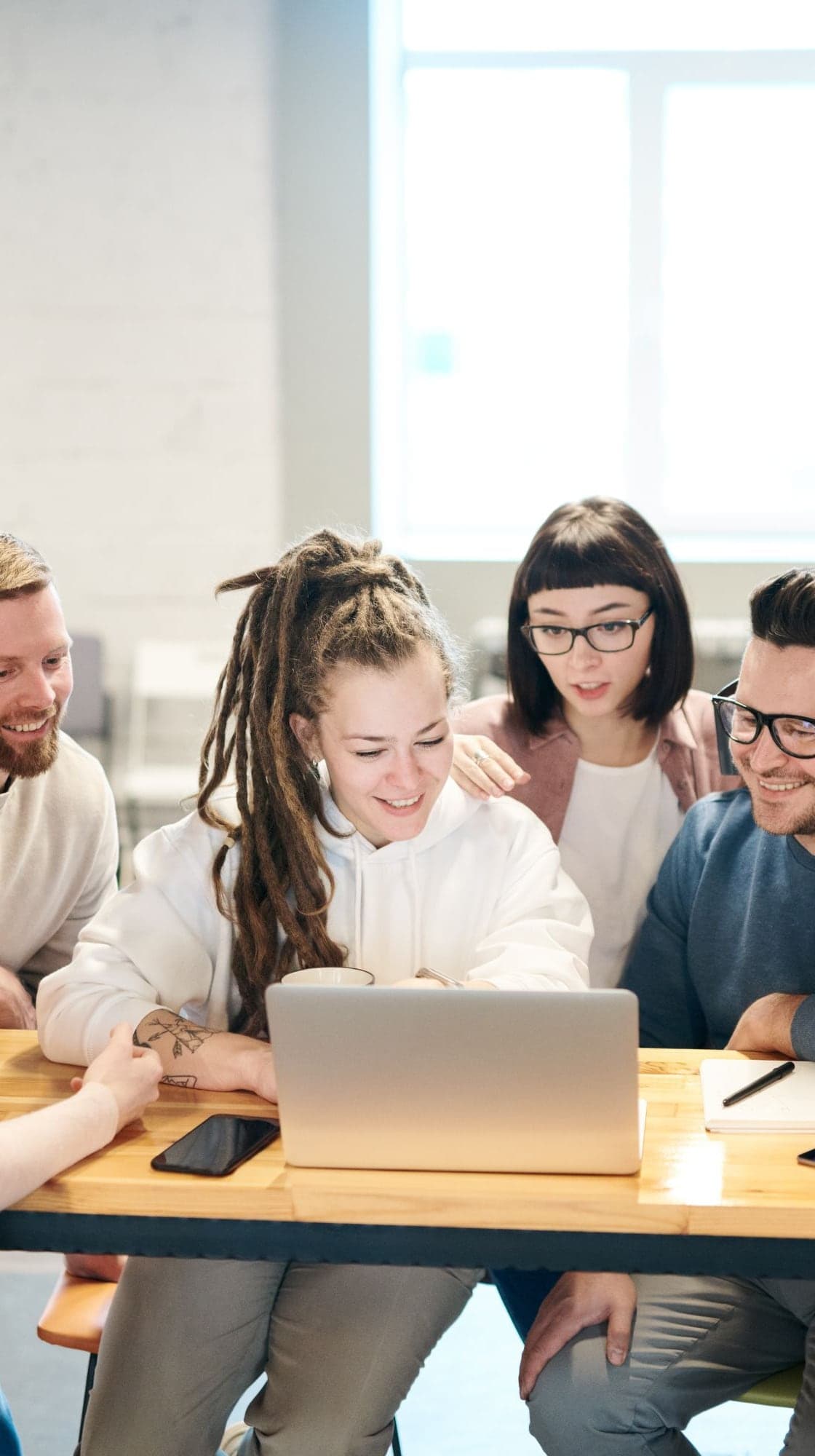 A team gathered around a laptop, working through a plan together
